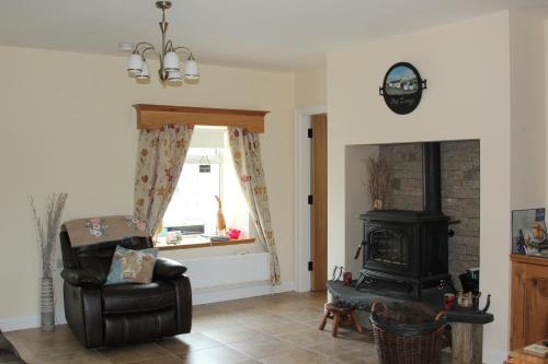 a living room with a chair and a stove at Pat Larry's Cottage in Greencastle