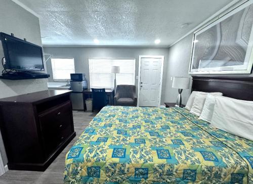 a hotel room with a bed and a television at Lemon Bay Motel in Englewood