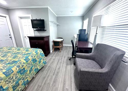 a bedroom with a bed and a desk and a chair at Lemon Bay Motel in Englewood