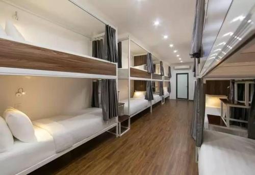 a room with three bunk beds with wooden floors at Hanoi Train Street Hostel in Hanoi