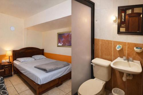 a small bathroom with a bed and a sink at Hotel Real de Cortés in Xalapa