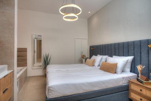 a bedroom with a large bed with a blue headboard at Keter HaSimta - כתר הסמטה in Safed