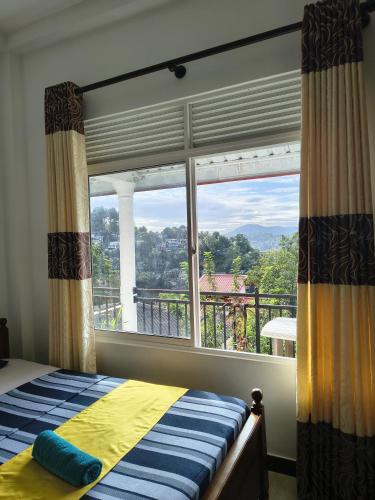 a bedroom with a bed and a large window at Grand Infinite Home Stay in Kandy