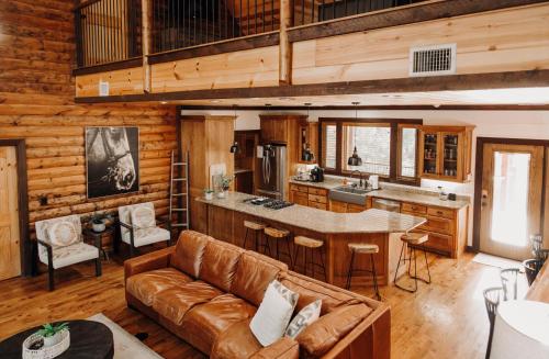 a living room with a couch and a kitchen at Heated Pool, 7 Bedroom Cabin, 6,000 Square Feet, Arcade! in Broken Bow