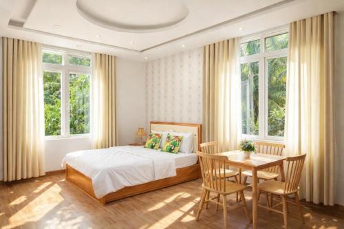 a bedroom with a bed and a table and chairs at Selima Hotel in Quy Nhon