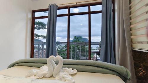 a bedroom with a window with swans on the bed at Forest Camp El Nido Extension in El Nido