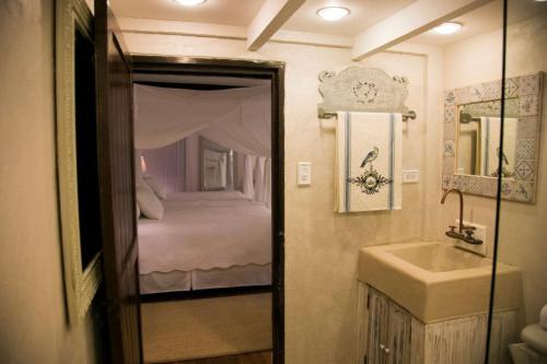 a bathroom with a sink and a bedroom with a bed at Reserva Monte Sagrado 1 in Utuado