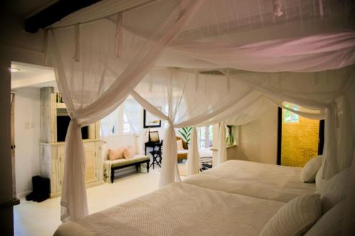 a bedroom with a white bed with a canopy at Reserva Monte Sagrado 1 in Utuado