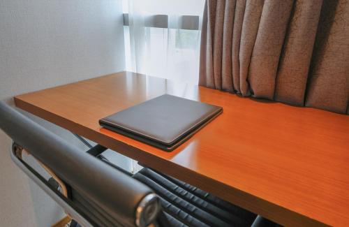 a laptop computer sitting on top of a wooden desk at Hotel Skypark Central Seoul Pangyo in Seongnam