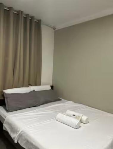 a white bed with two towels on top of it at Ashelma resort in Dauis
