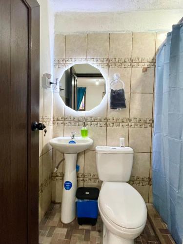 a bathroom with a toilet and a sink and a mirror at Casa Mama Wela in San Pedro La Laguna