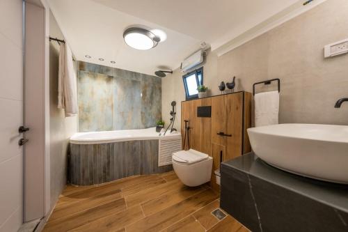 a bathroom with a sink and a tub and a toilet at Tzfat Regal - צפת ריגל in Safed