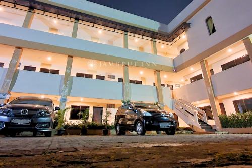 two cars parked in front of a building at Jambrut Inn in Jakarta
