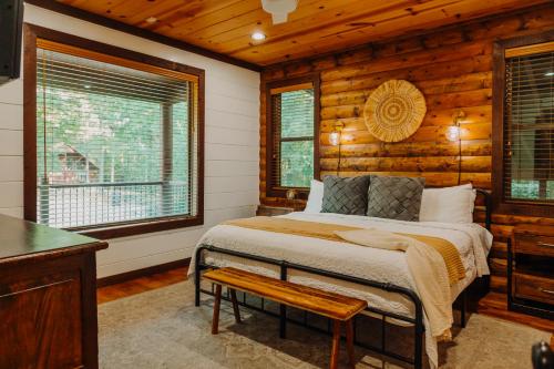 a bedroom with a bed in a room with wooden walls at Heated Pool, 7 Bedroom Cabin, 6,000 Square Feet, Arcade! in Broken Bow