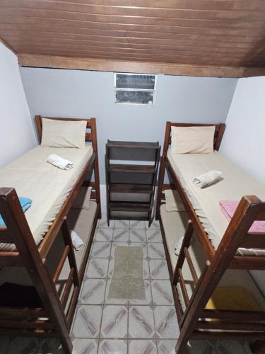 a room with two bunk beds and a chair at EsPAÇO RUSTIK in Santa Cruz Cabrália