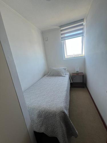 a small bedroom with a bed and a window at Vista a los volcanes in Puerto Montt