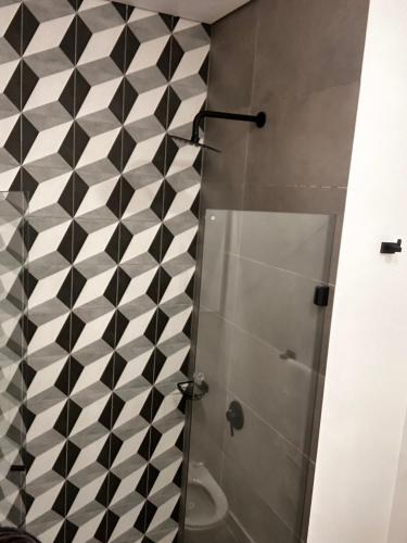 a bathroom with a shower with black and white tiles at Aparta Suite Centro Internacional Edificio 33DC Piso 29 Estación Trasmilenio Calle 34 in Bogotá