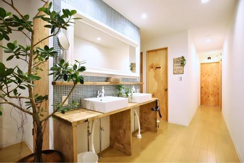 a bathroom with two sinks and a large mirror at IZA Enoshima Guest House in Fujisawa