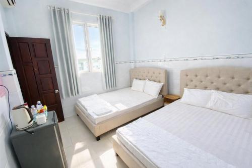 a bedroom with two beds and a window at Phước Hưng 1 Hotel in Vĩnh Long
