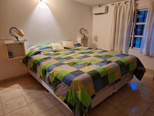 a bedroom with a bed with a colorful blanket at La Popelina in Valle Hermoso