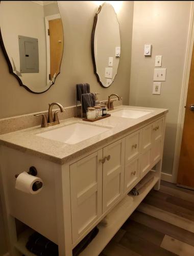a bathroom with two sinks and two mirrors at Cozy condo at Attitash Mountain Village in Bartlett