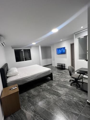 a bedroom with a bed and a desk and a television at Alma del Mar in Volcán Chimborazo