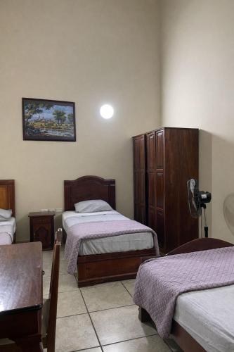 a hotel room with two beds and a table at Hotel Real de Cortés in Xalapa