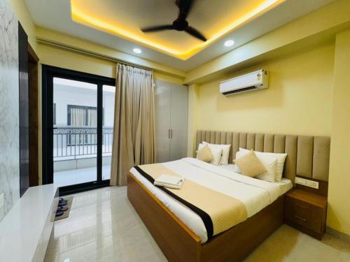 a bedroom with a large bed with a balcony at The Grand Hotel Akshay in Gurgaon