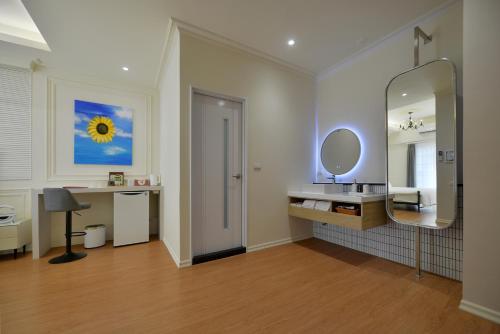 a bathroom with a mirror and a sink and a desk at Station B&B in Tainan