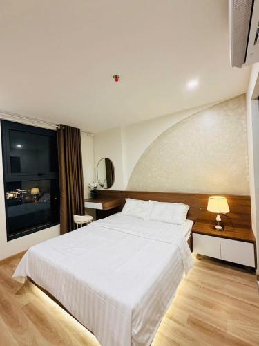a bedroom with a large white bed and a desk at Smile House - With In-unit Laundry & Kitchen in Sapa