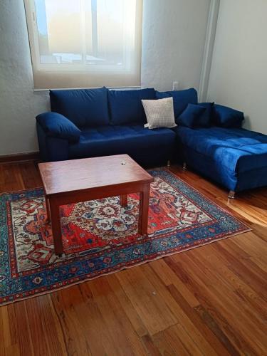 a blue couch with a coffee table in a living room at Roma Sur Comodo departamento completo in Mexico City