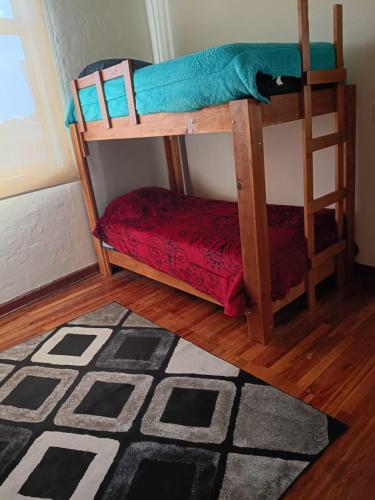 a room with two bunk beds and a rug at Roma Sur Comodo departamento completo in Mexico City