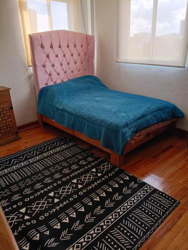 a bedroom with a bed and a window and a rug at Roma Sur Comodo departamento completo in Mexico City