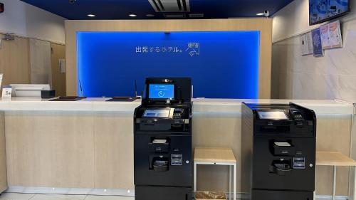 two atm machines sitting in front of a counter at Toyoko Inn Kita-asaka-eki Nishi-guchi in Asaka
