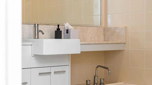 a bathroom with a sink and a mirror at Pipi's On The Beach 1 - 2 Fletcher Street in Byron Bay