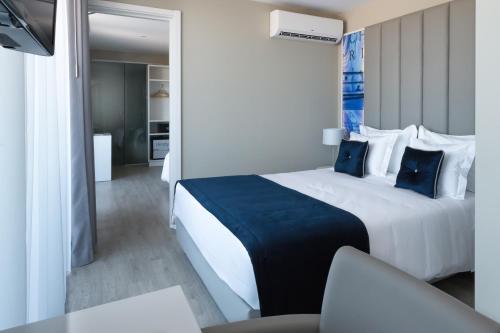 um quarto de hotel com uma cama grande com travesseiros azuis em Lisbon Sao Bento Hotel em Lisboa