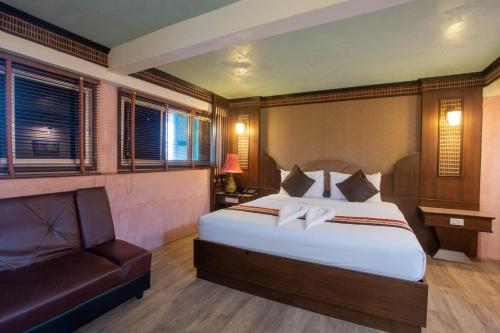 a bedroom with a large bed and a couch at P1 House Phitsanulok in Phitsanulok