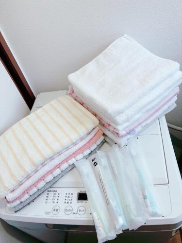 a pile of towels sitting on top of a washing machine at 谷町線歩く5分 梅田駅まで8分 Wi-Fiあり 今年リフォーム済み in Osaka