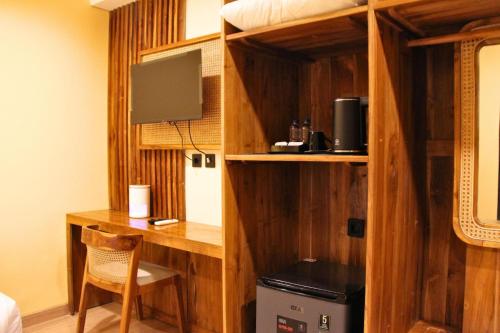 ein Zimmer mit Schreibtisch und Fernseher in einem Zimmer in der Unterkunft AB Hotel Kuta in Kuta