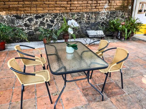 a table and chairs with a vase of flowers on it at Shanti Home in Tepoztlán