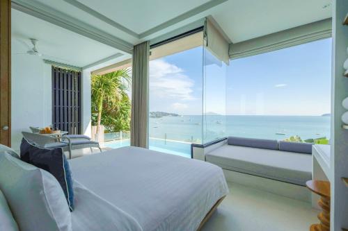 a bedroom with a bed and a view of the ocean at Bandara Pool Villas, Phuket in Panwa Beach