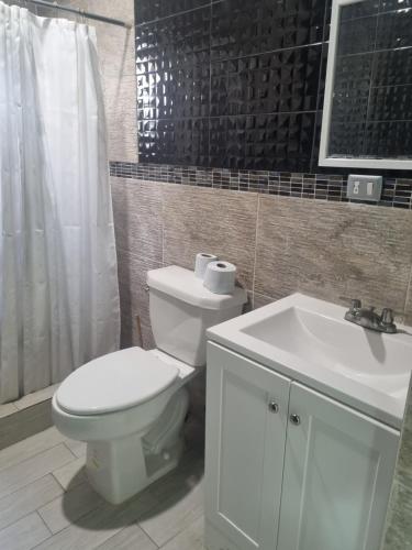ein Badezimmer mit weißer Toilette und Waschbecken in der Unterkunft Libano in Manuel F. Martínez