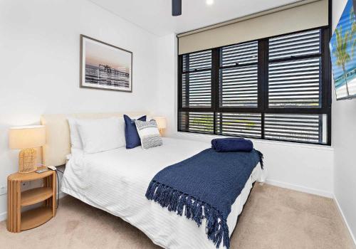 a bedroom with a bed and a window at Aqua Cove - Marina Escape in Shellharbour