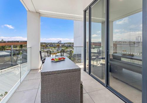 a balcony with a table and a bowl of fruit on it at Aqua Cove - Marina Escape in Shellharbour