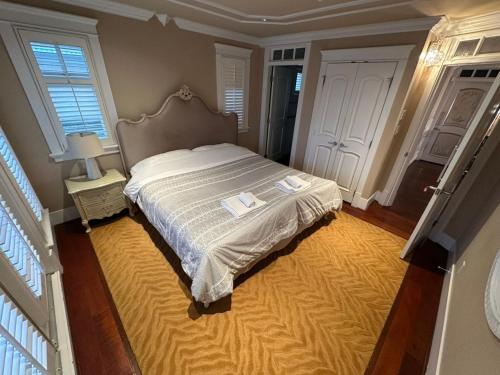 a bedroom with a large bed with a yellow rug at Luxury Room with Private Washroom in Prime Location in Vancouver