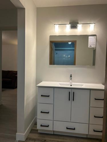 a bathroom with a white sink and a mirror at Rimbey Motor Inn in Rimbey