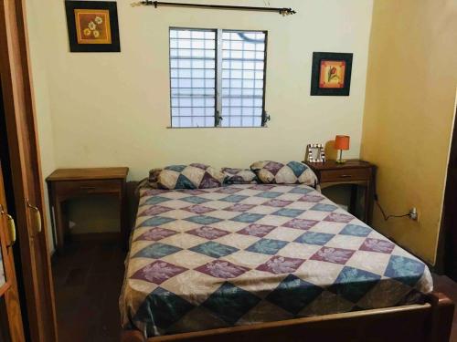 a bedroom with a bed with a quilt on it at Casa estilo campestre in Chitré