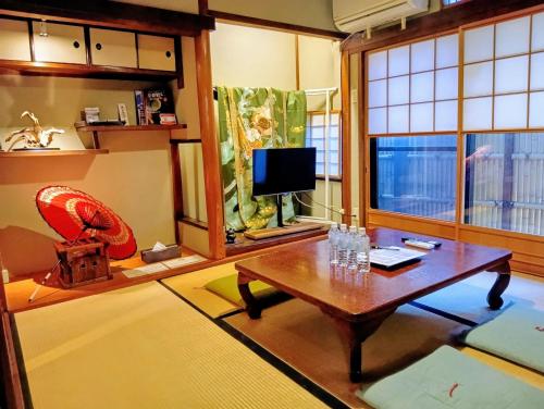 a living room with a table and a tv at Our-Turn Traditional Machiya near Heian Shrine in Kyoto