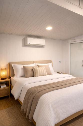 a bedroom with a large bed with white sheets and pillows at Little Mountain Nest in Haad Pleayleam