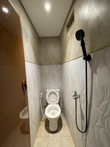 a small bathroom with a toilet and a shower at Sanur Backpacker Room Bali in Sanur
